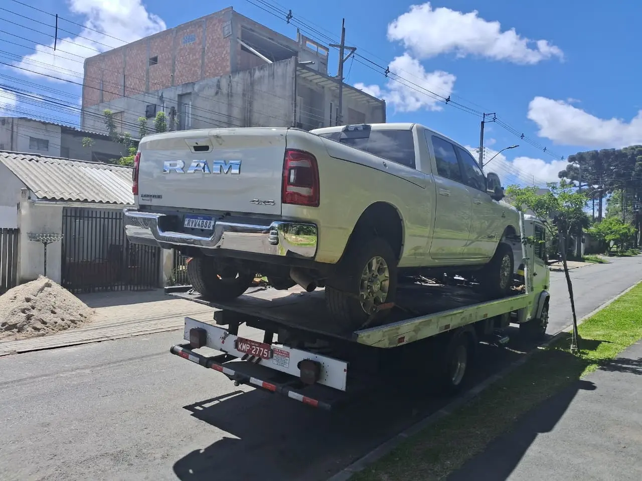 Guincho transportando caminhonete prata em rua residencial de Curitiba