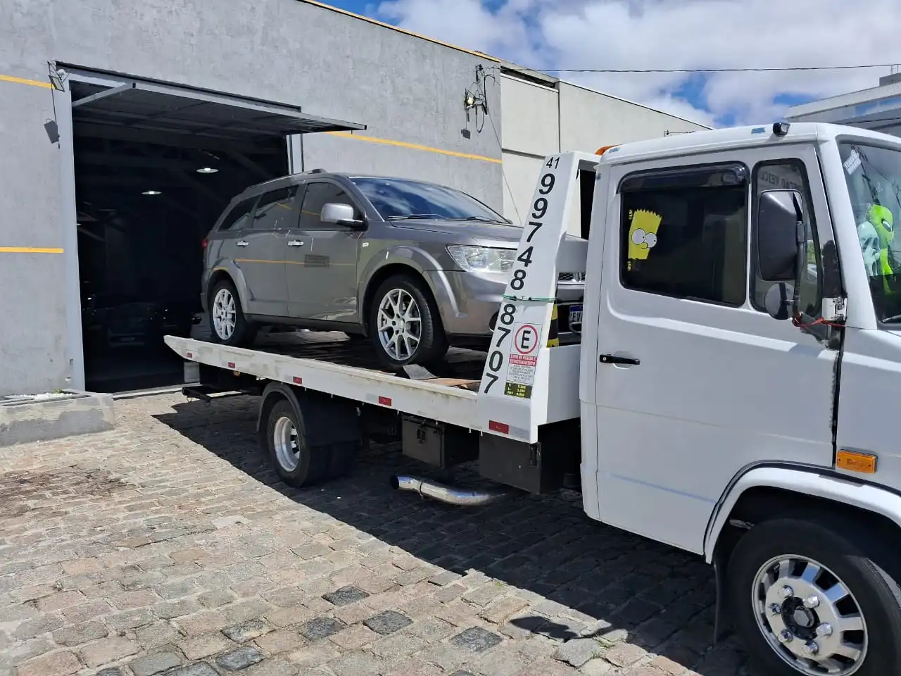 Guincho 24h rebocando automóvel prata em pátio de oficina em Curitiba