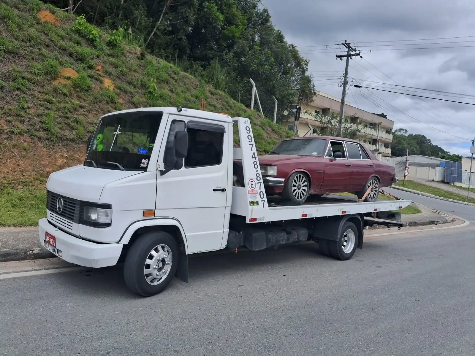 Guincho transportando carro marrom em rodovia de Curitiba com segurança e rapidez
